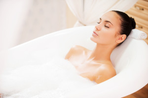 Total relaxation. Attractive young woman keeping eyes closed while enjoying luxurious bath